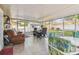 The porch includes an exterior dining table as well as a comfortable recliner in an enclosed, screened space at 4606 Copper Ln, Plant City, FL 33566