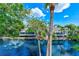 Scenic pond view with fountain, surrounded by palm trees, and a building with screened porches at 4611 Duhme Rd # 1A, St Petersburg, FL 33708