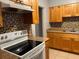 Kitchen features wood cabinets, mosaic tile backsplash, and modern appliances at 5211 Jersey S Ave, Gulfport, FL 33707