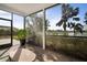 The screened in porch has a view of the palm trees and pond behind the house at 5460 Sandy Shell Dr, Apollo Beach, FL 33572