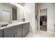 Bathroom featuring gray vanity cabinets, white countertop, a large mirror, and a walk in closet at 5460 Sandy Shell Dr, Apollo Beach, FL 33572
