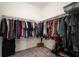 Walk-in closet displaying the rods and shelves full of clothes and luggage at 5460 Sandy Shell Dr, Apollo Beach, FL 33572