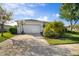 Spacious driveway leading to a two-car garage with a basketball hoop and mature landscaping at 5460 Sandy Shell Dr, Apollo Beach, FL 33572