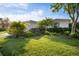 Charming single-story home with mature landscaping, lush green grass, and a well-maintained lawn at 5460 Sandy Shell Dr, Apollo Beach, FL 33572