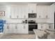 Modern kitchen featuring white cabinets, granite countertops, and stainless steel appliances at 5460 Sandy Shell Dr, Apollo Beach, FL 33572