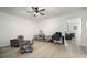 Living room featuring chairs, a ceiling fan, desk, and animal enclosures at 5460 Sandy Shell Dr, Apollo Beach, FL 33572