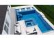An aerial view shows a modern pool with seating, hot tub, and nearby lounge space for relaxing or entertaining outside at 5460 Sandy Shell Dr, Apollo Beach, FL 33572