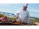 A chef grills steaks outside with an ocean view for a delicious beachfront dining experience at 5500 Gulf Blvd # 4228, St Pete Beach, FL 33706