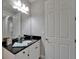 Elegant bathroom vanity featuring black granite counters, white cabinets, and a large mirror at 606 Winterside Dr, Apollo Beach, FL 33572