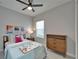 Stylish bedroom with a dresser, a cozy bed with decorative pillows, and bright natural light at 606 Winterside Dr, Apollo Beach, FL 33572