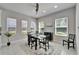 Bright dining area featuring a modern table set, tile flooring, and natural lighting at 606 Winterside Dr, Apollo Beach, FL 33572