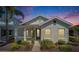 Twilight view of a charming single-story home with landscaped front yard and welcoming porch at 606 Winterside Dr, Apollo Beach, FL 33572