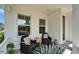 Relaxing front porch with comfortable seating and a vibrant outdoor rug for a cozy ambiance at 606 Winterside Dr, Apollo Beach, FL 33572
