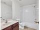 Clean bathroom featuring tile floors, a vanity, and shower-tub combo with white tile surround at 6205 Ibispark Dr, Lithia, FL 33547