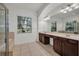 Well-lit bathroom featuring double vanity, large mirror, and a walk-in shower with a soaking tub at 6205 Ibispark Dr, Lithia, FL 33547