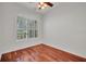 Cozy bedroom with wood flooring and plantation shutters, showcasing natural light and minimalist style at 6205 Ibispark Dr, Lithia, FL 33547