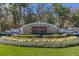 Elegant FishHawk Ranch stone entrance sign with well-maintained landscaping and palm trees at 6205 Ibispark Dr, Lithia, FL 33547