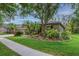 Beautiful single-story home with lush lawn, mature trees, and manicured garden beds at 6205 Ibispark Dr, Lithia, FL 33547