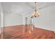 Spacious living area featuring gleaming hardwood floors, a chandelier, and transom window at 6205 Ibispark Dr, Lithia, FL 33547
