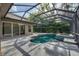 Covered pool and hot tub with patio, landscaping, and enclosure in a backyard oasis at 6205 Ibispark Dr, Lithia, FL 33547
