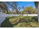Expansive backyard with lush lawn, mature trees, and secure white fencing at 6302 N 39Th St, Tampa, FL 33610