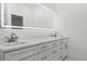 Bathroom featuring marble countertops with double sinks, white cabinets, and a lighted mirror at 6302 N 39Th St, Tampa, FL 33610