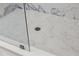 Shower with gray hexagon-shaped tiles on the floor and marble-patterned shower surround at 6302 N 39Th St, Tampa, FL 33610