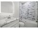 Bathroom showcasing a marble countertop vanity and tub-shower combo with patterned tiles at 6302 N 39Th St, Tampa, FL 33610