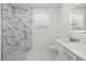 Bathroom featuring white cabinets, marble countertops, patterned shower tiles, and a glass shower at 6302 N 39Th St, Tampa, FL 33610