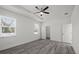 Bright bedroom with wood-look floors, a ceiling fan, and two windows offering natural light at 6302 N 39Th St, Tampa, FL 33610