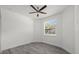 Bedroom featuring gray wood-look floors, a ceiling fan, and a window with blinds at 6302 N 39Th St, Tampa, FL 33610