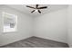 Bright bedroom with a ceiling fan, window with blinds, and attractive gray wood-look flooring at 6302 N 39Th St, Tampa, FL 33610