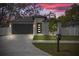 Charming home features a modern front door, well-manicured lawn, and a spacious two-car garage at 6302 N 39Th St, Tampa, FL 33610