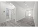 Bright open hallway with sleek flooring and modern finishes, leading to a bathroom and multiple rooms at 6302 N 39Th St, Tampa, FL 33610