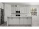 Modern kitchen featuring white cabinets, stainless steel appliances, and a marble countertop island at 6302 N 39Th St, Tampa, FL 33610