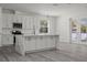 Bright, modern kitchen with white cabinets, stainless steel appliances, and a large marble island at 6302 N 39Th St, Tampa, FL 33610