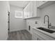 Neat laundry room with sink, white cabinets, and a window for natural light at 6302 N 39Th St, Tampa, FL 33610