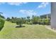 Spacious backyard featuring a lush lawn, mature landscaping, and partial views of the canal at 6317 Marbella Blvd, Apollo Beach, FL 33572