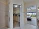 Bathroom with tiled shower and views to walk-in closet and main bedroom at 6317 Marbella Blvd, Apollo Beach, FL 33572