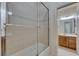 Bright bathroom featuring a tiled shower and a vanity with wood cabinets at 6317 Marbella Blvd, Apollo Beach, FL 33572