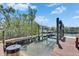 Wooden dock with boat lift, bordered by lush greenery, and offering waterfront enjoyment at 6317 Marbella Blvd, Apollo Beach, FL 33572