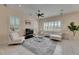 Bright living room with white furniture, shuttered windows, ceiling fan, and tile floors at 6317 Marbella Blvd, Apollo Beach, FL 33572