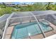 Aerial view of screened-in pool and spa surrounded by a brick patio at 6317 Marbella Blvd, Apollo Beach, FL 33572