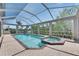 Sparkling screened-in pool and spa with an expansive brick deck, perfect for relaxation and recreation at 6317 Marbella Blvd, Apollo Beach, FL 33572