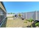 Fenced backyard featuring a stone fire pit, chairs, lush plantings, and a built-in grill, perfect for relaxation at 7019 Wiseman Run Dr, Sun City Center, FL 33573