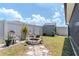 Private fenced backyard with stone fire pit, lush landscaping, and storage shed perfect for relaxing and entertaining at 7019 Wiseman Run Dr, Sun City Center, FL 33573