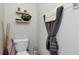 Clean bathroom showcases toilet with bidet feature and stylish decor, including floating shelves and textured towels at 7019 Wiseman Run Dr, Sun City Center, FL 33573