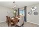 Dining room with a decorative light fixture and sliders to the backyard; the table is set for a meal at 7019 Wiseman Run Dr, Sun City Center, FL 33573