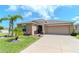 Inviting home showcasing lush landscaping, a well-manicured lawn, and an attached garage at 7019 Wiseman Run Dr, Sun City Center, FL 33573