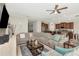 Spacious living room with a large sectional sofa, ceiling fan, and open layout into the kitchen area at 7019 Wiseman Run Dr, Sun City Center, FL 33573